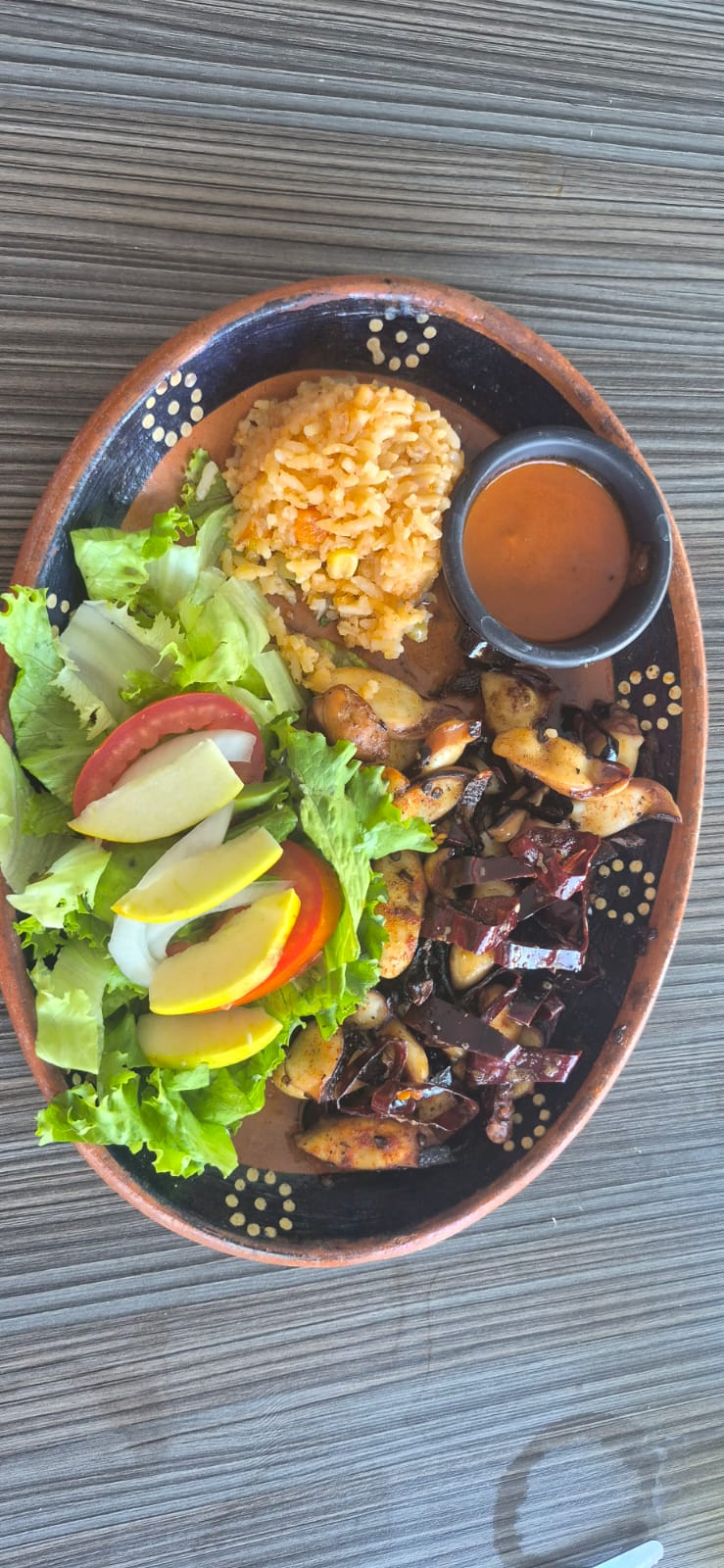 Plato de pulpo con arroz y ensalada.